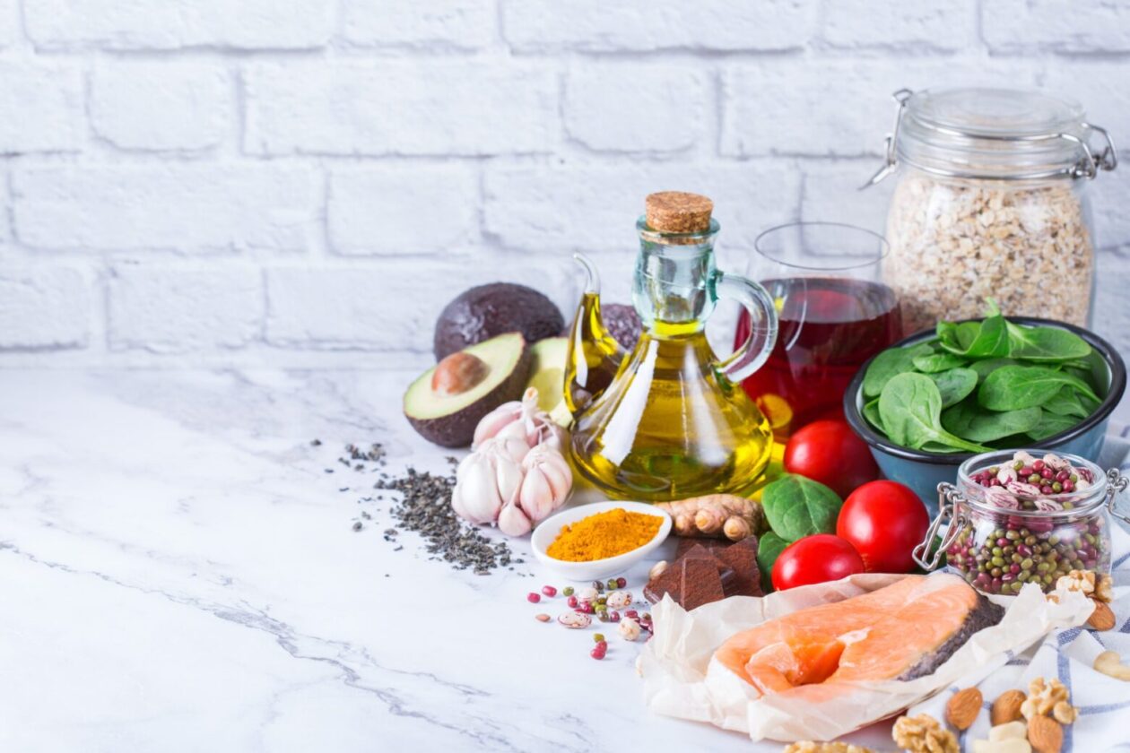 Balanced diet food concept. Assortment of healthy food low cholesterol, spinach avocado red wine green tea salmon tomato flax chia seeds turmeric garlic nuts olive oil